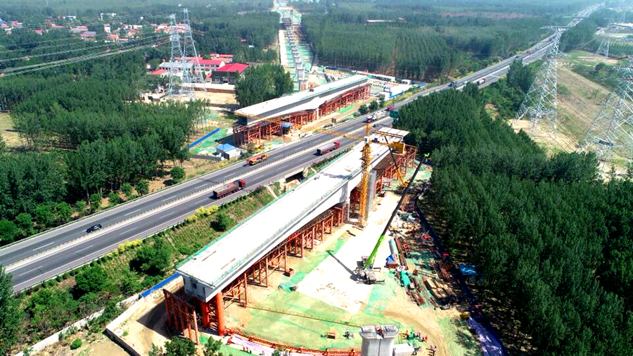 5月25日凌晨5時，經過一夜的奮戰，京雄城際鐵路重難點控制工程——固安特大橋跨廊涿高速公路72+128+72m墩頂不平衡轉體連續梁成功完成轉體，這是京雄城際鐵路建設取得的突破性建設成果。圖為轉體前連續梁在高速公路兩側分節段澆筑。
