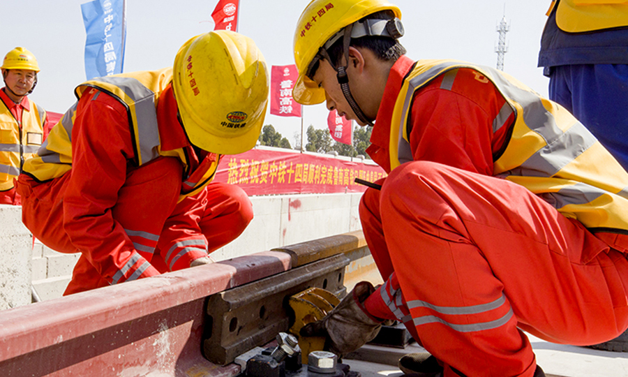 據悉，魯南高鐵日曲段靜態驗收預計持續1個月左右，靜態驗收結束后將進行動態驗收、聯調聯試、動態檢測及運行試驗等，有望在年底前開通運營。圖為中鐵十四局鋪軌工人進行鋼軌龍口固定工作。