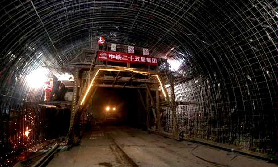 針對鐵峰山隧道復雜地質，中鐵二十五局采取有毒有害氣體檢測、沉降觀測等措施，運用地質雷達、超前預報、激發極化法等探測方法，對復雜地質進行“望聞問切”，有效規避安全風險。圖為施工人員綁扎加固二襯鋼筋。（蔡如錦 攝）