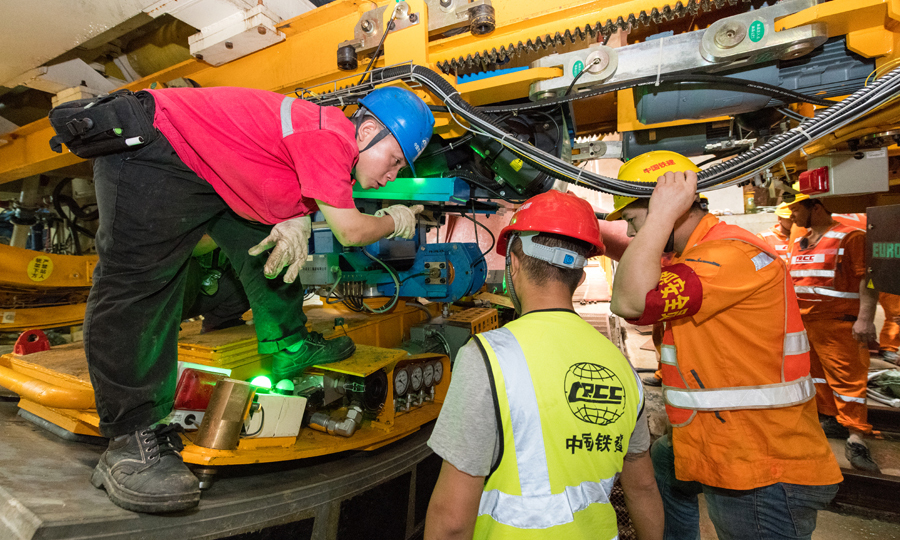 圖為鐵建重工技術人員正在向施工班組介紹管片拼裝機。
