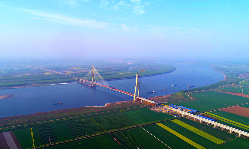 石首長江大橋是湖北省高速公路網縱五線“棗陽—石首”的過江通道，起點順接潛江至石首高速公路江陵段，終點接江南高速公路，設計時速每小時100公里。該橋全長12.2公里，為雙塔斜拉橋，一跨820米飛躍長江天塹，大橋綜合施工難度位居世界同類橋梁前列。圖為石首長江大橋遠景。