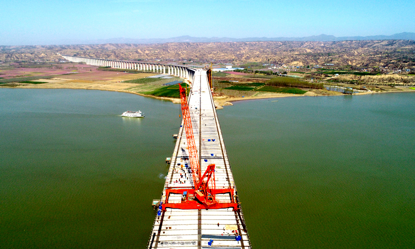 蒙華鐵路三門峽黃河公鐵兩用大橋是目前世界上同類型橋梁連續頂推長度最長、頂推重量最重、設計活載最大的橋梁，將于今年10月1日全線通車，此次公路橋面板架設完成，標志著大橋上層公路橋面全面貫通，為下步濕接縫澆筑和橋面結合施工打下基礎。圖為三門峽黃河公鐵兩用大橋主橋鋼梁最后一塊公路橋面板架設完成。