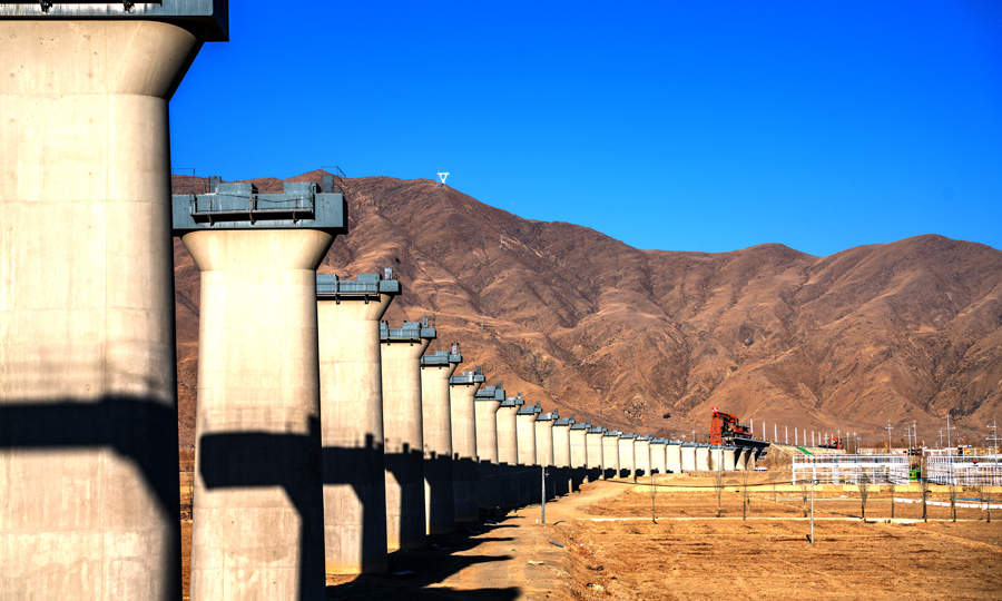 據介紹，聲屏障梁比普通T梁更重，其重量高達152.9噸。現有的鐵路貨車載重量不能滿足裝運條件。為此，項目部專門購置了8輛特種平板車，以滿足聲屏障橋梁的裝運要求。圖為杰德秀特大橋與正在鋪架的架橋機。