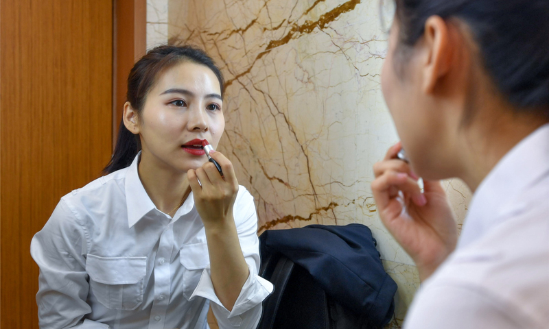 早7點15分，何倩倩執勤的最早航班準時開航。駕駛崗位雖然不要求直接面對旅客，但她從不放松對自己儀容儀表的要求，在工作崗位時刻保持良好的精神狀態。圖為3月5日早上6時，何倩倩準備出門上班。（唐蜀全 攝）