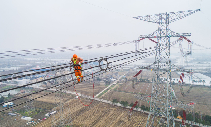 本次改接工程將有效提升特高壓線路運行可靠性，確保華東地區特高壓主干網架輸電安全，為長三角一體化戰略貢獻能源力量。圖為2月1日，施工人員正在改接工程現場進行走線，巡查特高壓線路。（新華社記者 徐昱 攝）