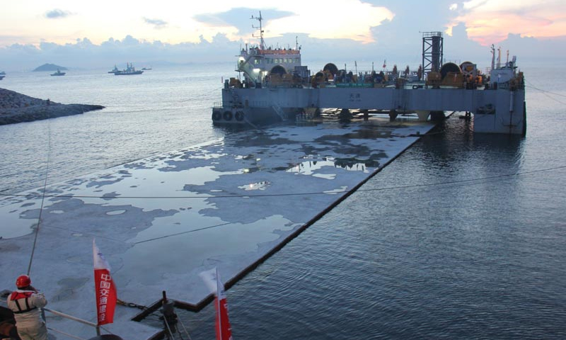 圖為2013年7月29日拍攝的港珠澳大橋島隧工程首節大型沉管浮運安裝施工現場。經過近28小時的艱苦奮戰，2013年7月30日，島隧工程首節180米標準管節（E3）順利完成浮運安裝任務，實現了國內首次外海無掩護、深水條件下的大型沉管安裝。新華社發（港珠澳大橋局提供）