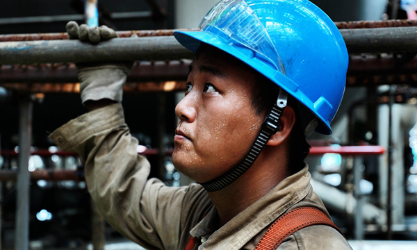 5月的廣州，太陽像火球一樣炙烤著大地，空氣似乎都要燃燒起來，但再熱的天也比不了1600余名工匠不分晝夜浴“汗”奮戰的熱情。從船體外側工作臺到均深25米的艙室，再到50米高的火炬塔頂，在看得見或看不見的地方，海油人翩翩起“舞”。圖為塢修現場工作場景。（李豫黔 攝）