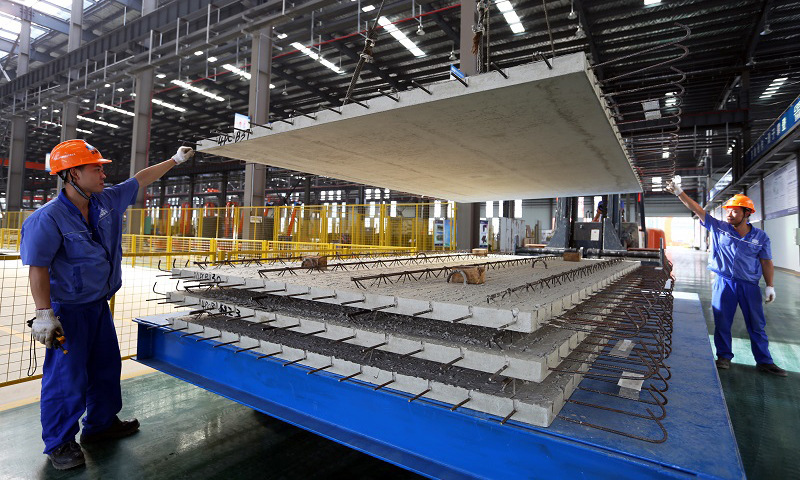 圖為建筑工人進行“樓板”裝車。