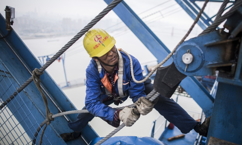 6月8日，50歲的楊仍財在架設主纜。（新華社記者 肖藝九 攝）