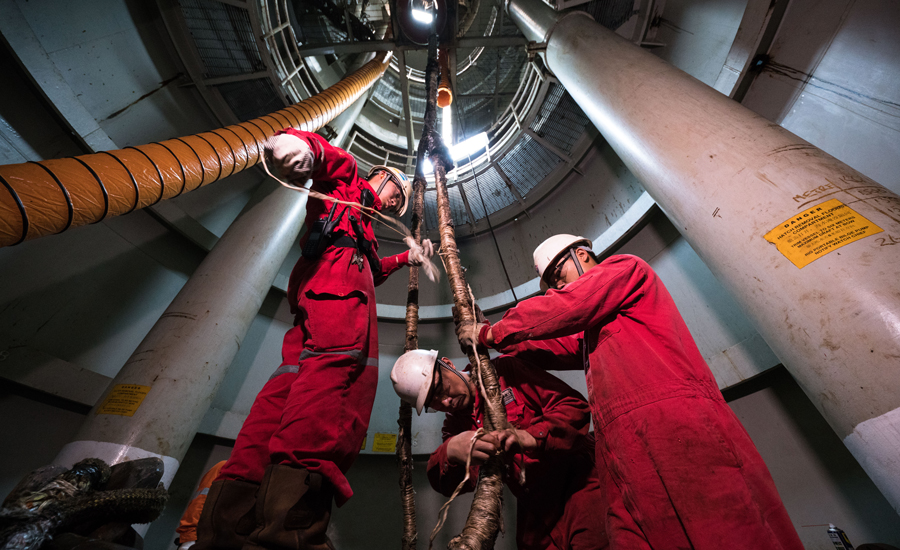 單點艙位于甲板下方30米深處，作業人員平均每天要上下攀爬8次以上。為了減少牽引纜繩的磨損，每次牽引之前工作人員都要為其纏上一層保護膜。（作者：李彥昭）