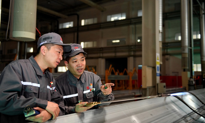 4月27日，周晶輝（右）與徒弟臧鐵軍進行烤槍火焰調整。（新華社記者 張楠 攝）