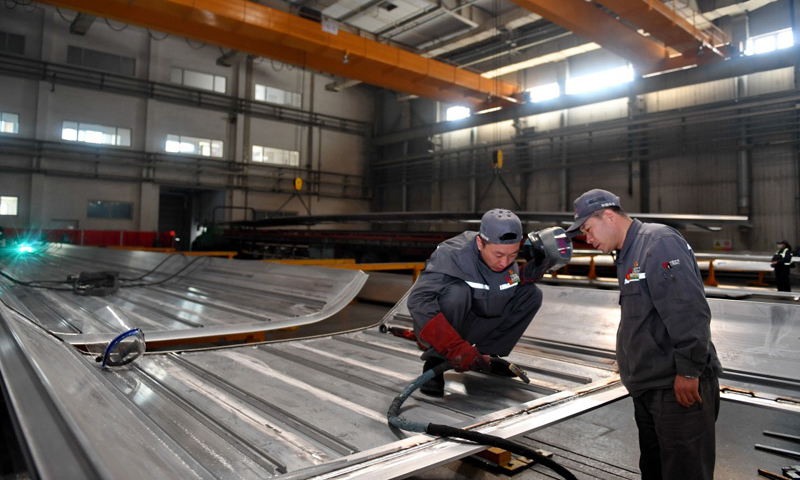 4月27日，周晶輝（右）與徒弟臧鐵軍一起研究改進高鐵車體焊接工藝。（新華社記者 張楠 攝）