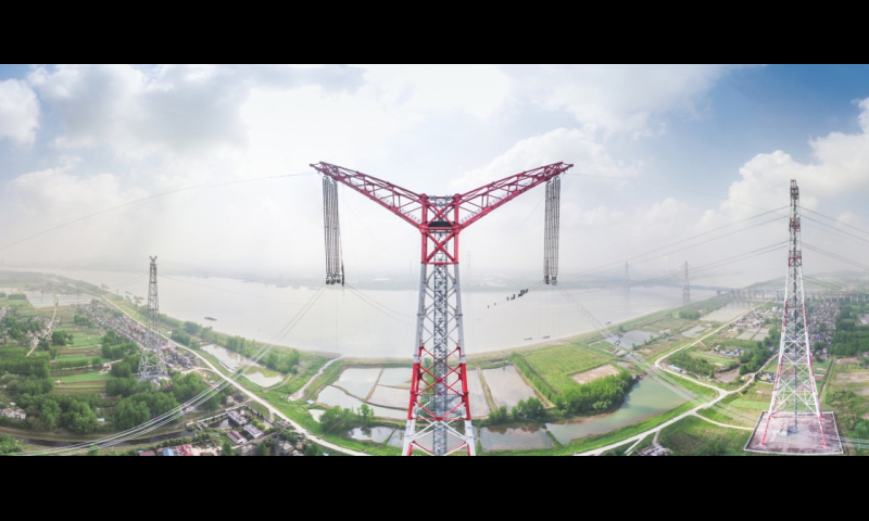 4月15日上午九時許，位于安徽省無為縣高溝鎮的±1100千伏吉泉長江大跨越架線北岸張力場正在緊張施工。一排排導線隨著線盤的轉動在工人們的監視下逐步向長江南岸的牽引場釋放。隨著西電東送±1100千伏“新疆準東—安徽皖南”特高壓直流工程的最后一相導線順利跨越天塹長江，世界電壓等級最高的特高壓大跨越——昌古特高壓長江大跨越工程全線貫通。圖中是導線展放后的昌古特高壓長江大跨越工程北岸跨越塔（無人機拍攝）。