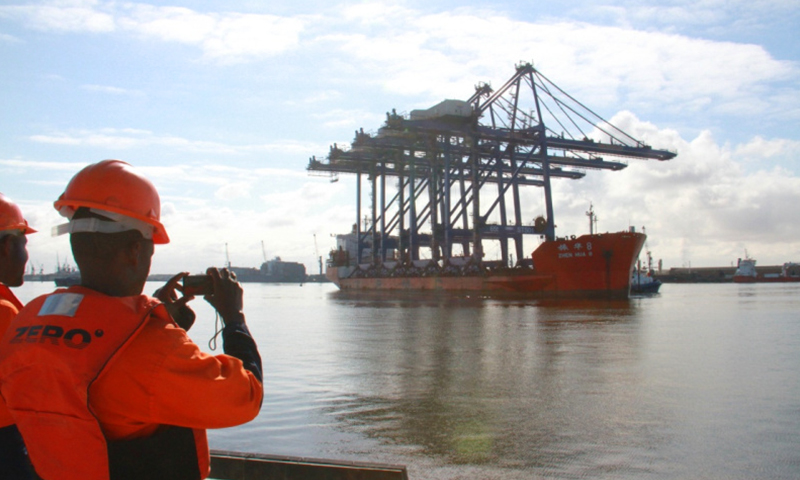 載著四臺巨大岸橋的貨輪9日上午緩緩靠向正在建設的納米比亞沃爾維斯灣集裝箱碼頭。納米比亞港務局工作人員等候運載著四臺岸橋的貨輪靠港。（新華社記者 吳長偉 攝）