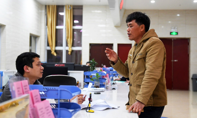 在廣西欽州港經濟技術開發區行政審批局，前來辦事人員（右）正在咨詢有關行政審批事宜。（新華社記者 陸波岸 攝）