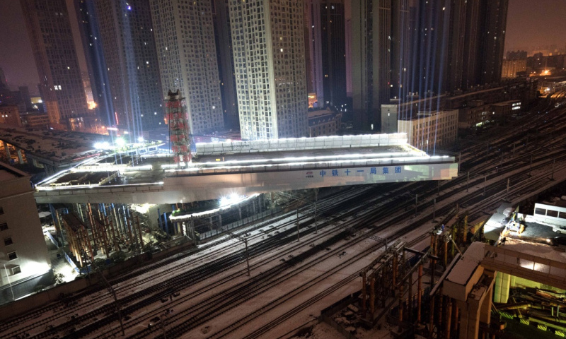 該轉體橋為武漢市常青路高架橋的重要部分，為鋼箱梁結構，轉體段全長135.2米，橋面總寬51米，跨越漢口火車站西咽喉岔區9股火車股道，且轉體的長臂端長91.4米，短臂端長43.8米，兩端橋長相差兩倍多，兩臂重量相差3600噸，具有極不對稱、極不平衡的特點。（新華社記者 杜華舉 攝）