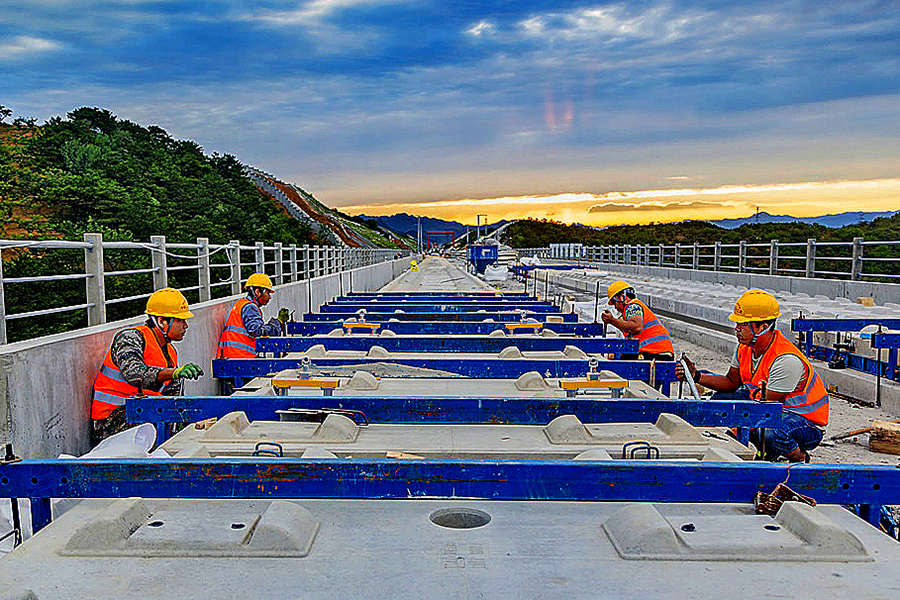 京哈高鐵在全線最長隧道梨花頂隧道建設中，鐵建人用智能“機械化部隊”取代傳統的“人海戰術”，確保了隧道施工內實外美。并在國內首次將牽引變電所建在了城市公園內，與同等標準戶外牽引變電所相比，占地面積減少了四分之三。圖為工人進行軌道板精調作業。（侯欽佩 攝）