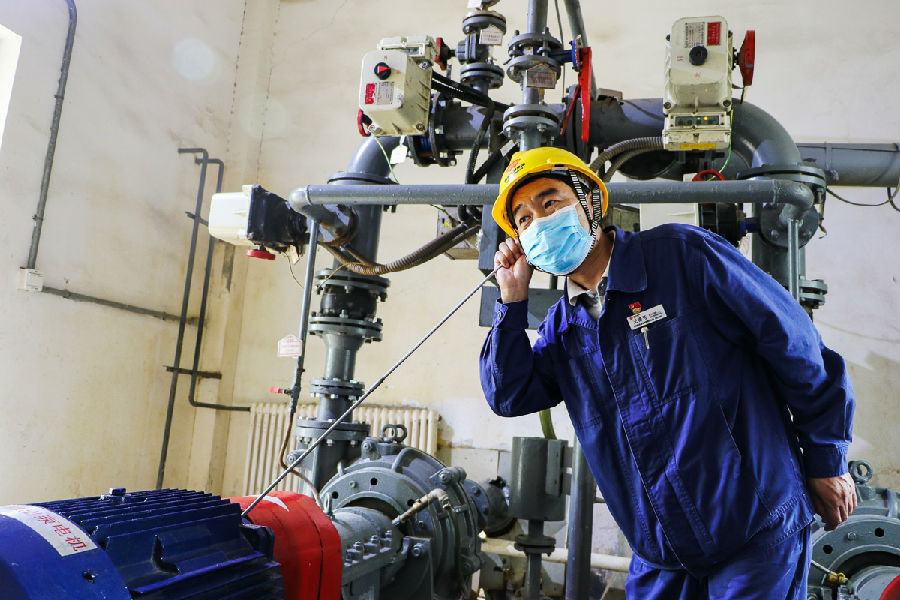 圖為春節期間，國家能源集團華北衡豐電廠灰硫運行一班班長王德芳在脫硫機房用聽針監聽石膏排除泵工作情況。這是王德芳第十四次春節過年在發電機組運行現場值守。（楊志剛 攝）