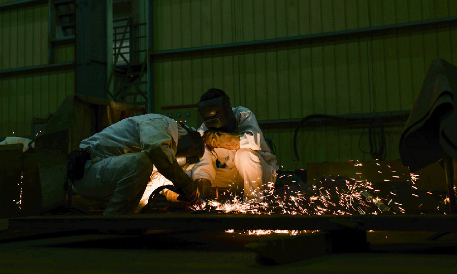 近日，中核華興一線鉚工陳喜文與田勇軍正在去除引弧板作業。（范錦紅 攝）