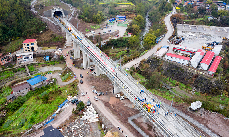 3月1日，隨著第一組500米長鋼軌鋪入無砟軌道，由中鐵十一局負責的鄭萬高鐵重慶段鋪軌工程正式啟動。圖為3月1日，在鄭萬高鐵重慶段施工現場，施工人員在進行鋪軌作業。(新華社記者 唐奕 攝)