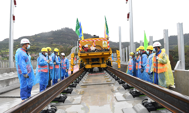 鄭萬高鐵是我國“八縱八橫”高速鐵路網中沿江通道和呼南通道的重要組成部分。線路起于河南省鄭州市，止于重慶市萬州區，新建線路全長約818公里，設計時速350公里。圖為3月1日，在鄭萬高鐵重慶段施工現場，施工人員進行鋪軌前的準備工作。(新華社記者 唐奕 攝)