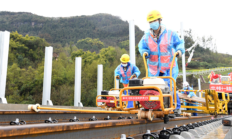 圖為3月1日，在鄭萬高鐵重慶段施工現場，施工人員進行鋪軌作業。(新華社記者 唐奕 攝)