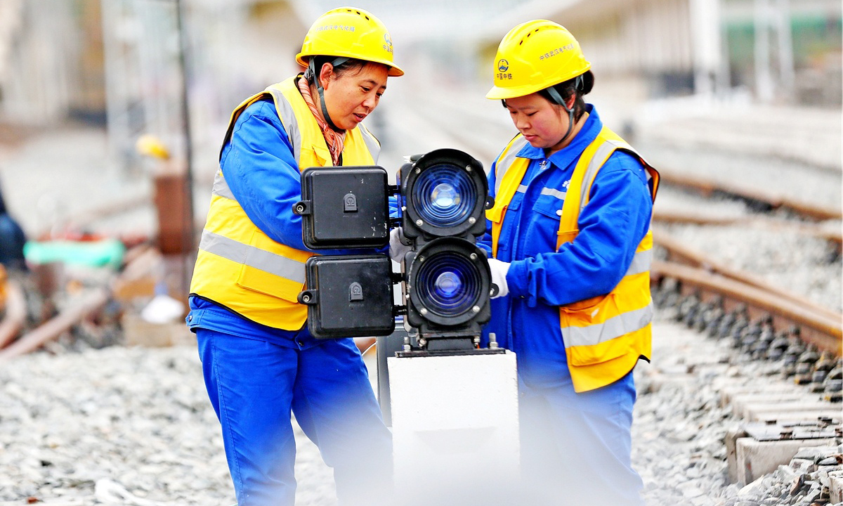 在施工現場，20歲的突擊隊隊員張玉倩正在專心致志地進行箱盒配線作業，分線、穿線……動作流暢連貫，猶如繡娘在穿針引線。突擊隊隊員平均年齡29歲，張玉倩是年齡最小的姑娘。她們擔負著管段內9個車站、9座信號樓的施工任務。為縮短工期，提高效率，隊員們打破常規，創新配線工藝，得到了專家的一致認可。圖為信號燈配線。