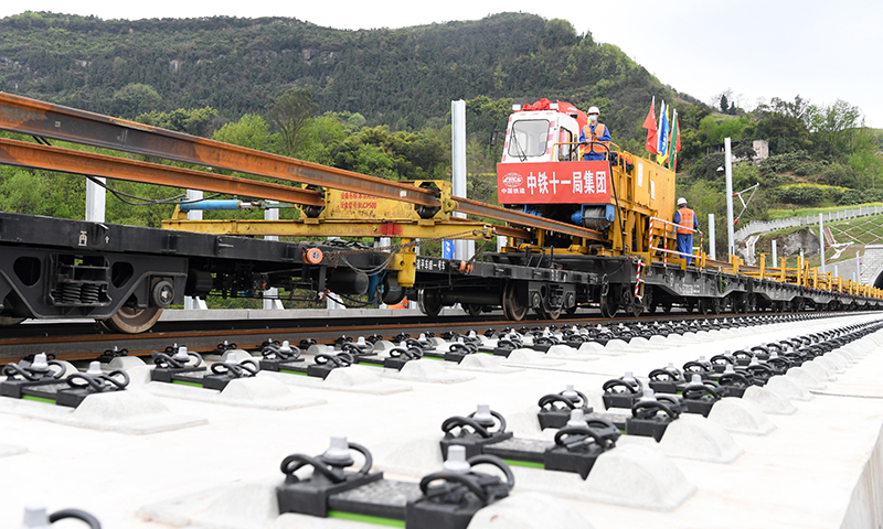 3月17日，“走單線鋪雙線”的施工技術在鄭萬高鐵重慶段鋪軌作業現場正式投入運用。這一技術填補了我國高鐵機械化跨線鋪軌作業技術空白。圖為BLCP500型本鄰兩線長軌鋪設機組進行機械化跨線鋪軌作業。（新華社記者 唐奕 攝）