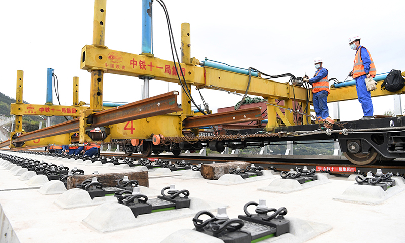 據了解，這次鄭萬高鐵重慶段鋪軌，首次運用了BLCP500型本鄰兩線長軌鋪設機組，在第一條線路鋪設完成、不需要中轉的情況下，對鄰線進行長軌鋪設，省去了換線鋪軌牽引車折返時間，減少了調車作業的次數，鋪軌準備時間減少約50%，大幅提升了鋪軌作業效率。圖為3月17日，BLCP500型本鄰兩線長軌鋪設機組進行機械化跨線鋪軌作業。（新華社記者 唐奕 攝）