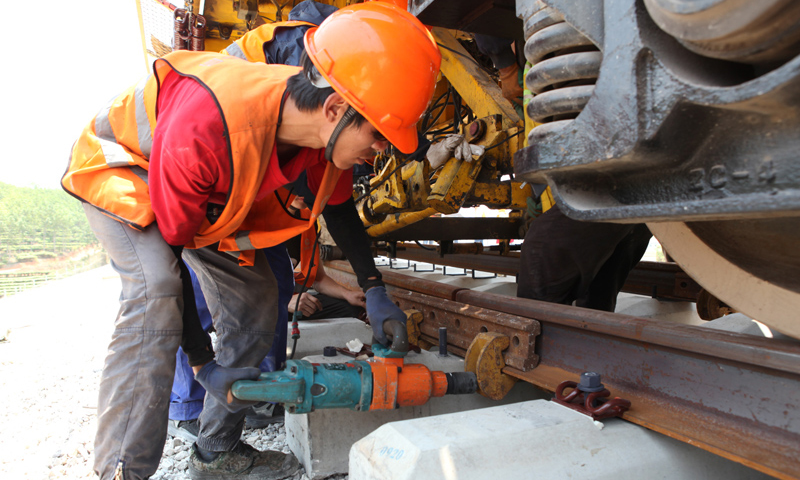 圖為4月24日，工人在景洪市大渡崗鄉大荒壩段進行鋪軌作業。新華社發（李云生 攝）
