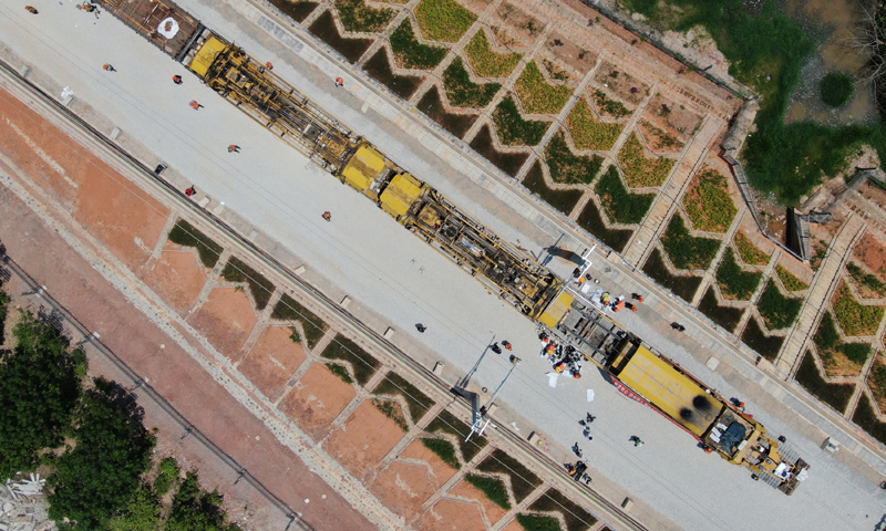 圖為4月24日，中鐵一局的鋪軌機在景洪市大渡崗鄉大荒壩段進行鋪軌作業。新華社發（李云生 攝）