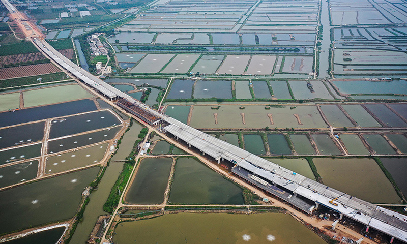 鶴港高速全長35公里，東起港珠澳大橋連接線，西至珠海高欄港，全線設置7處互通立交、18座（特）大橋和兩座隧道，橋隧比達89.7%。項目建成后將成為珠江口西岸地區快速對接粵港澳大灣區核心區域的主通道。圖為5月1日拍攝的珠海鶴港高速公路二期工程高欄港樞紐立交橋建設現場。（新華社記者 劉大偉 攝）