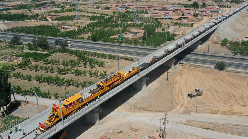 圖為5月30日，中鐵十一局建設者操作CPG500型鋪軌機在中蘭客專甘肅段新墩特大橋上進行鋪軌作業。（新華社記者 陳斌 攝）