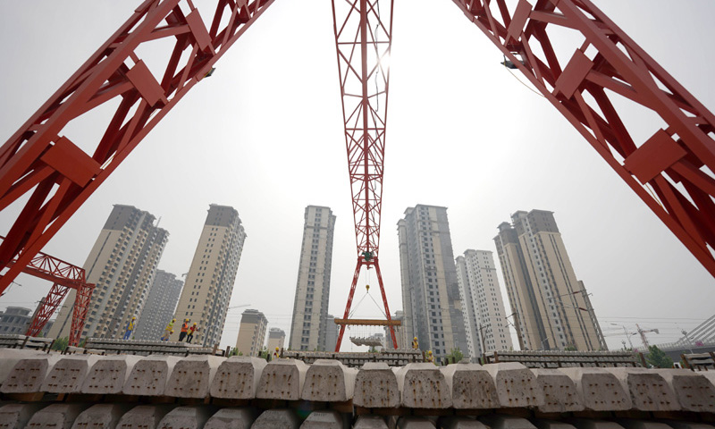 6月1日，在和（順）邢（臺）鐵路鋪軌基地，中鐵六局施工人員駕駛鋪軌機開始鋪設鐵軌，這標志著和邢鐵路進入鋪軌施工階段。圖為中鐵六局的建設者在搬運軌枕。（新華社記者 駱學峰 攝）