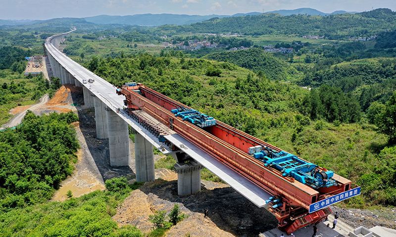 6月7日，由中鐵四局承建的貴南高鐵銀坡河特大橋順利合龍。該橋位于貴州省獨山縣境內，全長約3.4公里，是貴南高鐵貴州段最長橋梁。圖為最后一片箱梁正在架設中。（新華社記者 劉續 攝）