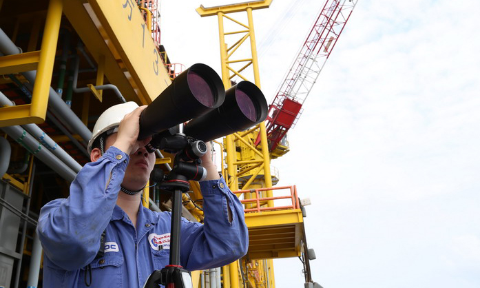 海管檢測系統上線后，氣田工作人員目視巡檢海管制度仍同時執行。圖為氣田工作人員用高倍望遠鏡巡視海面。