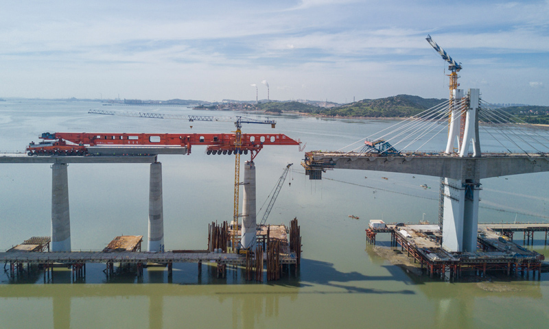 “昆侖號”是目前世界唯一的千噸級運架一體機，自2020年首次在新建福廈鐵路湄洲灣跨海大橋建設現場亮相以來，共架設40米高鐵箱梁298孔。圖為7月11日，在新建福廈鐵路湄洲灣跨海大橋建設現場，“昆侖號”在架設該線路最后一孔40米箱梁。（新華社記者 宋為偉 攝）