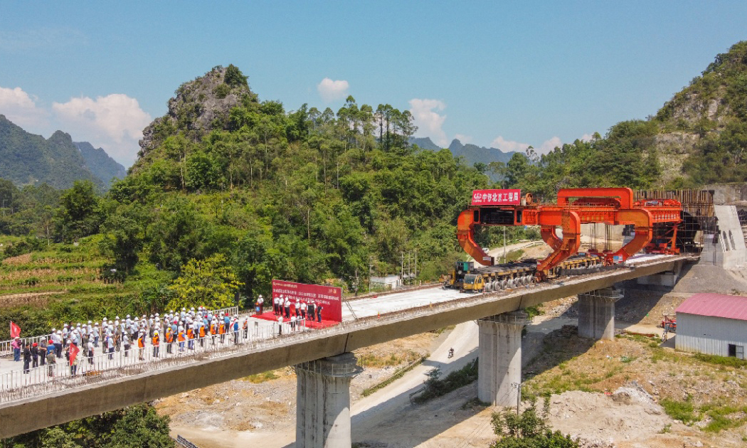 7月26日，一榀長32米、重900噸的箱梁穩穩落在貴南高鐵澄江雙線特大橋墩臺上，標志著這座全線長度最長、連續梁跨度最廣、拼裝梁體量最大的大橋施工取得重要進展。至此，中國中鐵北京工程局貴南高鐵項目都安制梁場612榀簡支梁架設施工圓滿完成，開始全面進入加速收尾階段，為后續無砟軌道道床施工奠定了基礎。