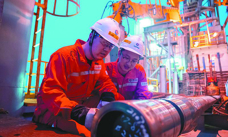 圖為鉆井監督現場檢查入井工具合格證書，核實工具技術數據準確無誤。