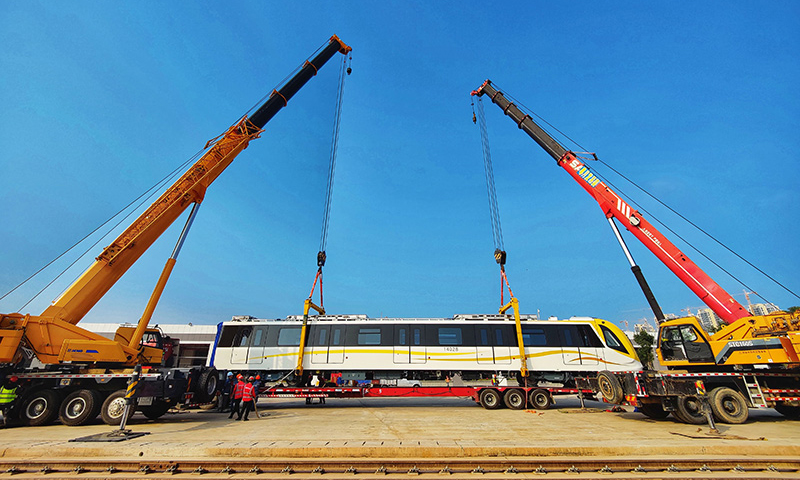 全長50.34公里的地鐵14號線是深圳東部首條地鐵快線，連接福田中心區、羅湖、大運新城、坪山中心等地區。圖為施工人員將深圳地鐵14號線首列電客車吊裝到軌道上。（新華社記者 劉大偉 攝）