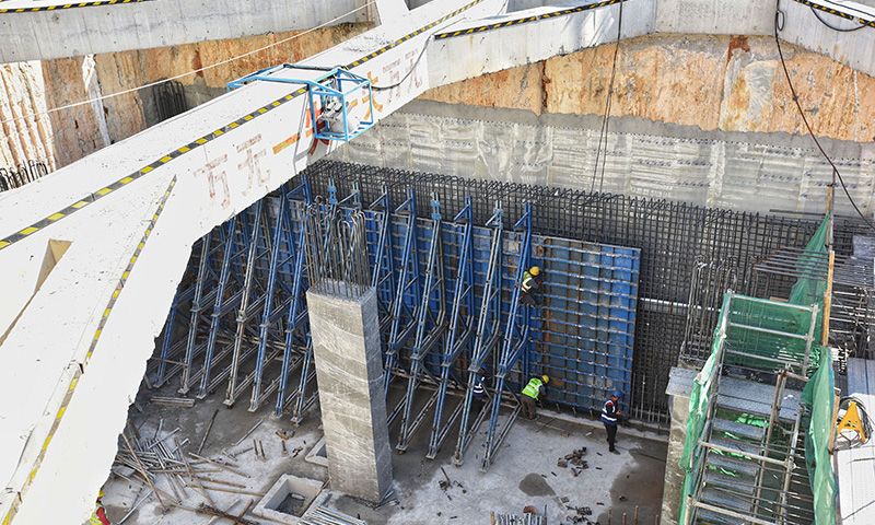 位于深圳龍崗區的地鐵3號線四期工程線路全長約9.28公里。作為深圳東部的軌道干線，地鐵3號線聯系福田—羅湖核心區與龍崗副中心，融合灣區發展，發揮中心城區的輻射帶動作用，實現龍崗東部組團與城市核心區的快速通連。圖為12月7日，施工人員在深圳地鐵3號線四期工程坪地六聯站工地吊裝混凝土護墻模板。（新華社記者 劉大偉 攝）