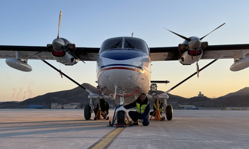 河北通航高度重視，把保障2022年冬奧會人工影響天氣安全運行作為首要任務，嚴格按照民航局和河北省人影中心要求，做好前期準備工作，并為后續工作制定專項保障措施。該公司共派出3架飛機，選調36名技術能力強、工作作風優良的機組人員參與保障，確保冬奧會保障任務順利圓滿完成。圖為機務人員檢查運12起落架。（馮文佳 華玉兆 攝）