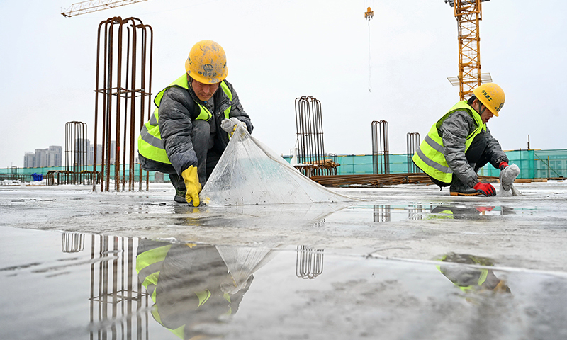 圖為2月6日，中鐵建工集團有限公司施工人員在新建福廈鐵路福州南站站房施工現場揭開混凝土樓板上的塑料保護膜。（新華社記者 林善傳 攝）
