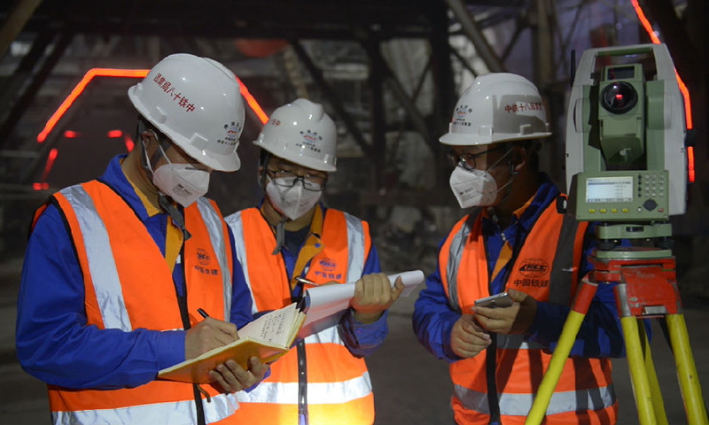 正在施工的九萬大山4號隧道全長15.5公里，是貴南高鐵廣西段最長的隧道，地質情況復雜，開挖難度極大,截止目前，該隧道已完成開挖13867米，剩余1598米，面對復雜的地質條件，該項目每天以25米的開挖速度向前掘進。圖為技術人員正在核實測量數據。