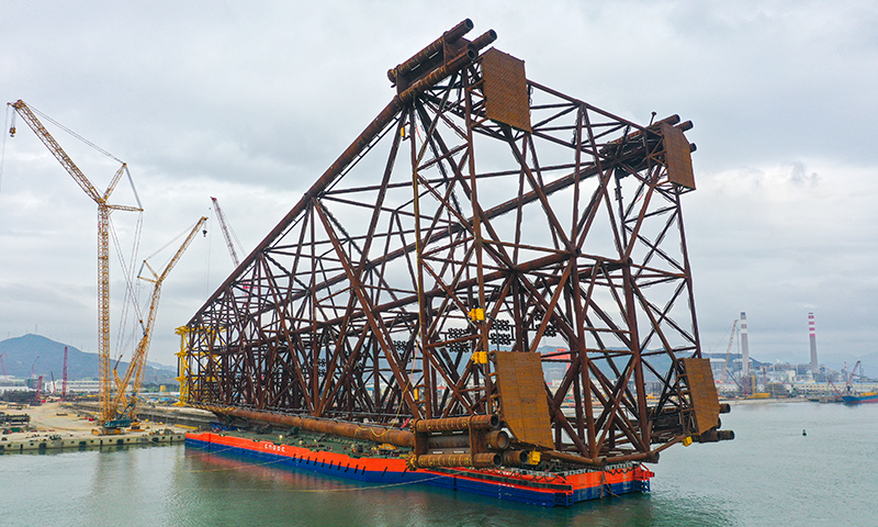 “海基一號”總高度302米，重量達3萬噸。在集團工程建設部指導支持下，項目組團隊調動各方優質資源，全面強化裝船風險管控和精細化管理，提前辨識出整個裝船過程中的風險點，并制訂詳細的應對預案，逐項反復檢查裝船準備細節。圖為亞洲第一深水導管架“海基一號”完成裝船作業，就位駁船。