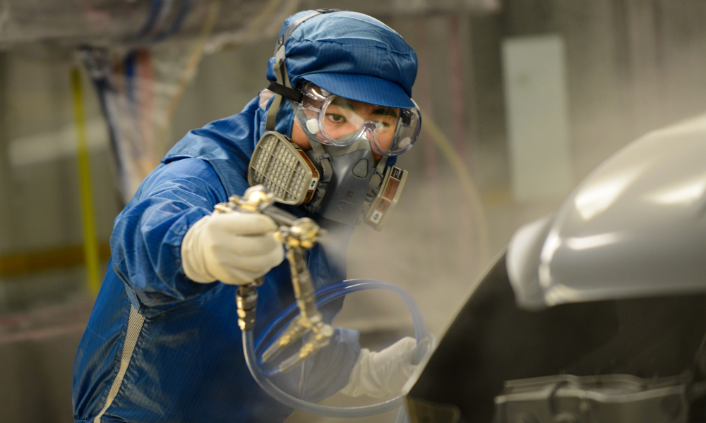 長安汽車的工作人員正在加班加點涂裝汽車。