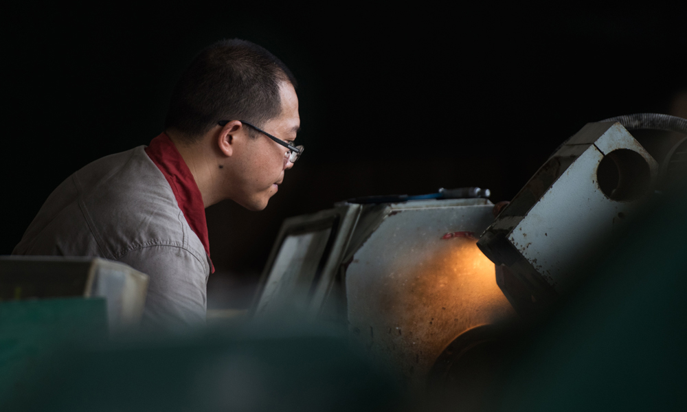 長江化工工作人員正在車床旁加工產品。