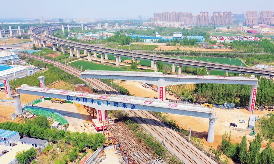 近日，中國中鐵旗下中鐵十局承建的濟（南）鄭（州）鐵路濟南上行聯絡線、下行聯絡線轉體橋同時跨越京滬鐵路和水（屯）白（馬山）鐵路，順利對接，成為濟鄭鐵路首座實現雙橋同轉的橋梁工程。該轉體橋為雙幅變梁高T型剛構橋，轉體長度128米，單幅轉體重量為6500噸，轉體過程中，兩橋實現了不同轉角、不等速同轉。圖為施工現場。 