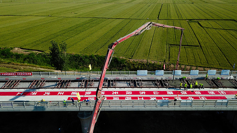 近期，中鐵上海局統籌疫情防控和項目建設，推進國家重點基建工程——濟鄭高鐵施工。5月21日，濟鄭高鐵山東德州段最后一榀箱梁架設完成，無砟軌道施工也于同日在長清黃河特大橋拉開序幕。圖為5月21日，在濟鄭高鐵山東長清黃河特大橋施工現場，中鐵上海局工作人員進行無砟軌道施工作業（無人機照片）。新華社記者 郭緒雷 攝