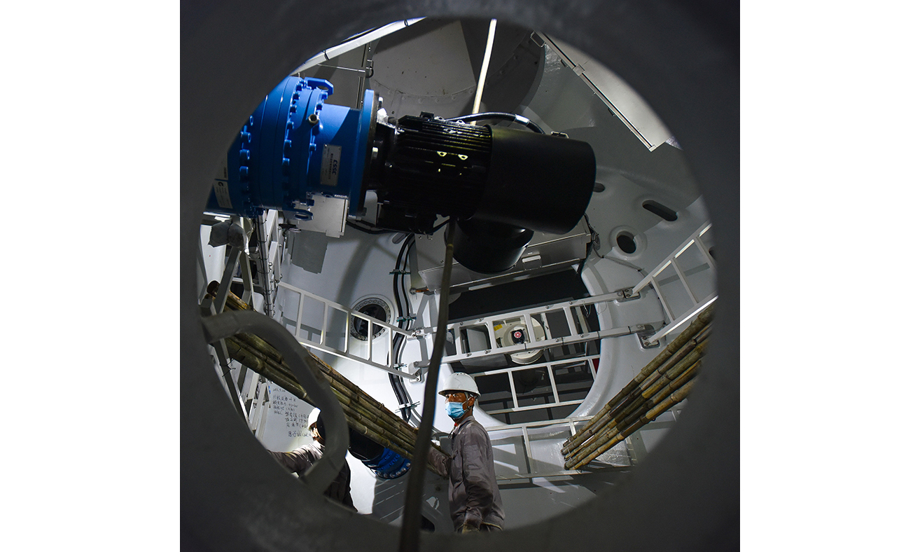 5月26日，工程人員在國內首臺深遠海浮式風電裝備“扶搖號”的風葉輪轂內為吊裝作業打螺栓。新華社記者 劉大偉 攝